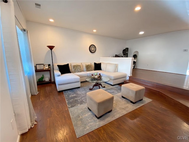 living room with wood-type flooring and ornamental molding