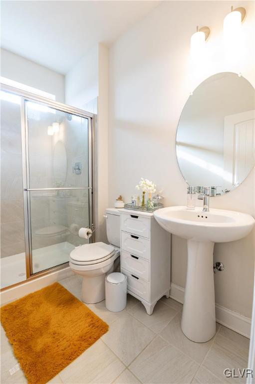 bathroom with walk in shower, tile patterned flooring, and toilet