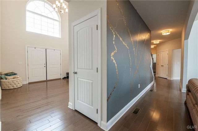 hall featuring a notable chandelier and hardwood / wood-style flooring