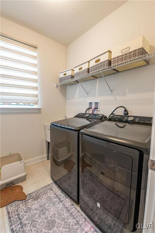 clothes washing area featuring light tile patterned floors and separate washer and dryer