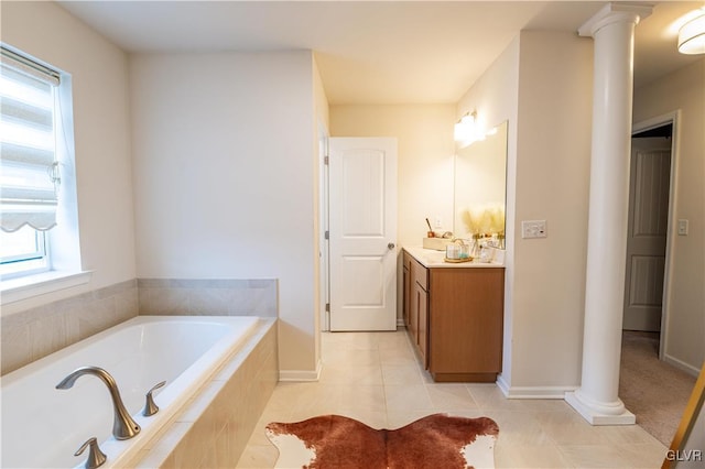 bathroom with ornate columns, tile patterned floors, vanity, and a relaxing tiled tub