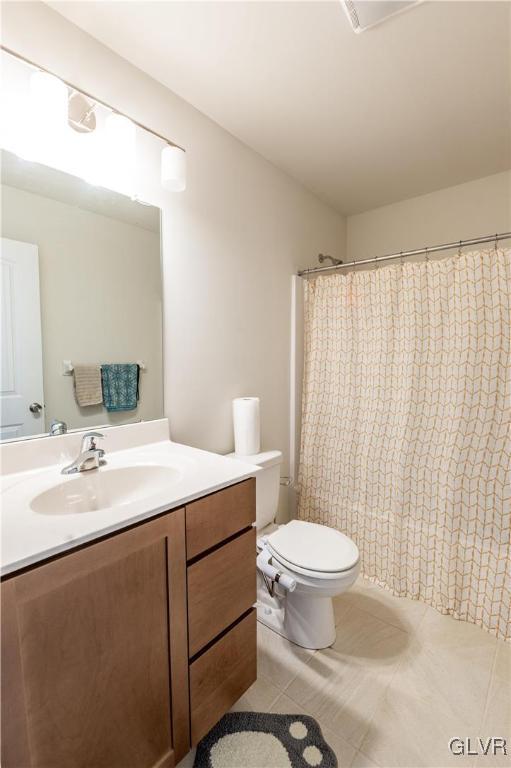 bathroom featuring toilet, tile patterned flooring, a shower with curtain, and vanity