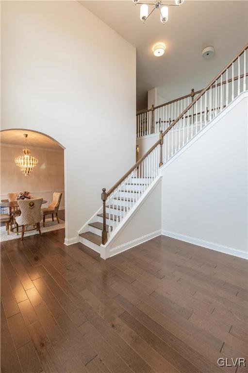 stairs with hardwood / wood-style flooring and a chandelier