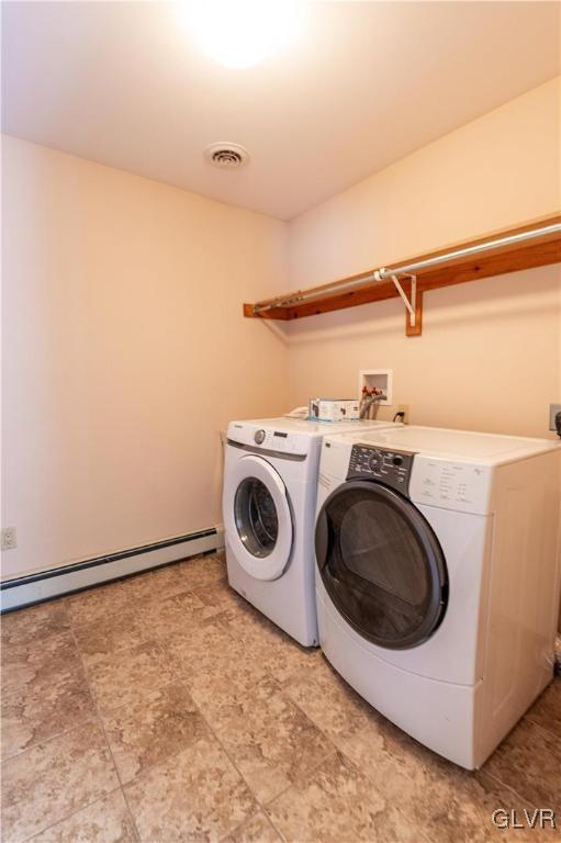 clothes washing area with baseboard heating and independent washer and dryer