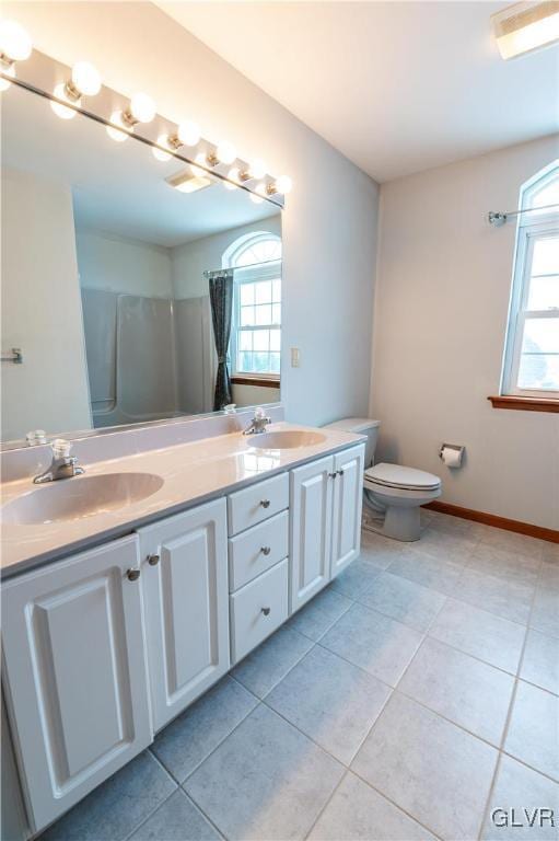 bathroom featuring curtained shower, tile patterned floors, vanity, and toilet