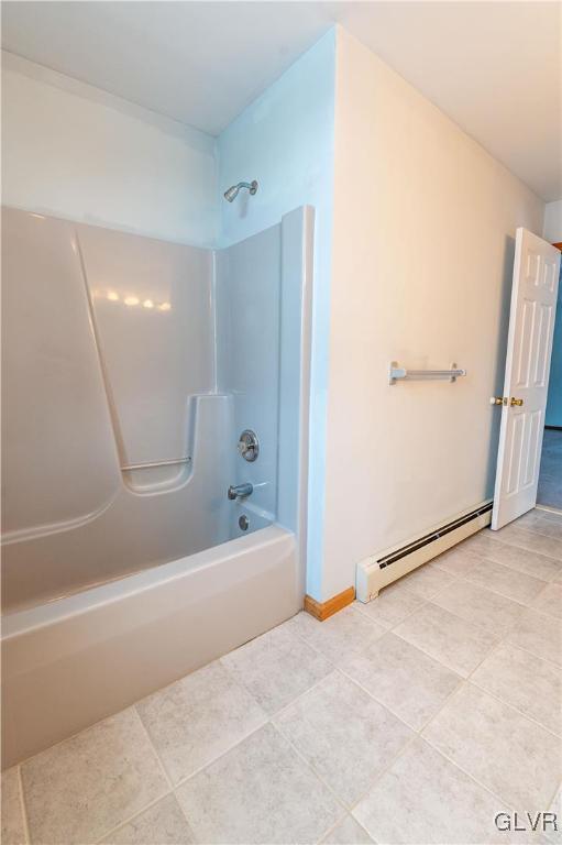 bathroom featuring tile patterned flooring, a baseboard heating unit, and bathing tub / shower combination