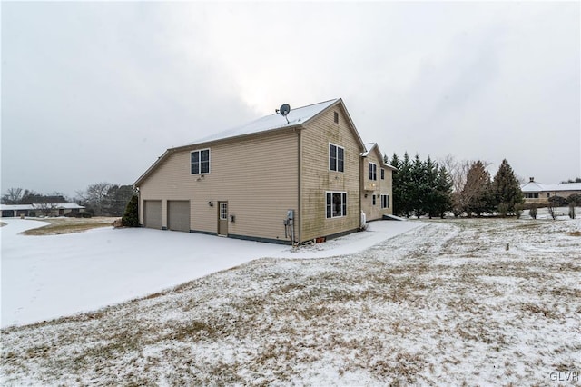 view of snowy exterior with a garage