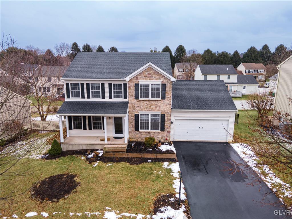 view of front of home featuring a garage, a front yard, and a porch