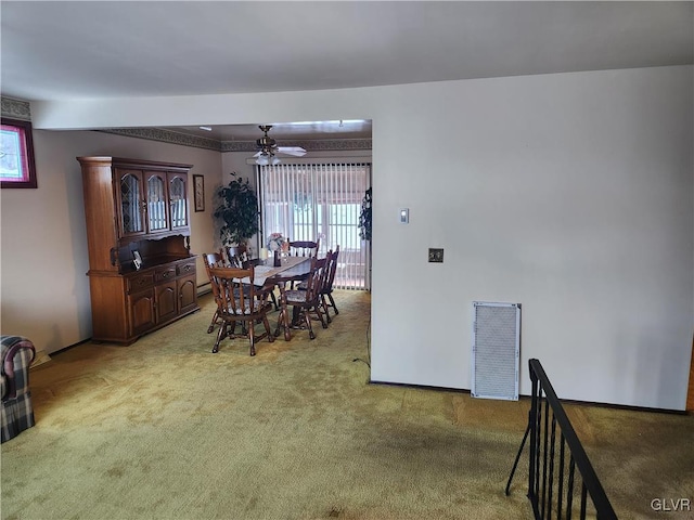 carpeted dining area with ceiling fan