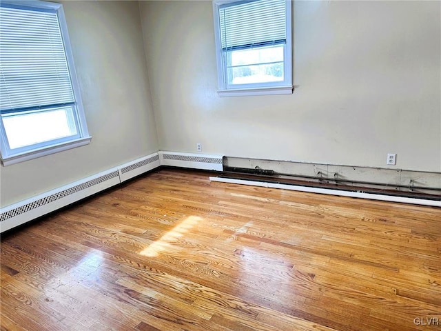 empty room with baseboard heating and wood-type flooring