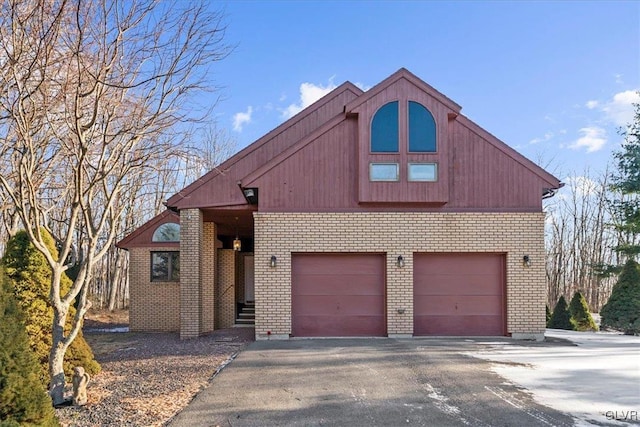 view of front of property with a garage, brick siding, and aphalt driveway