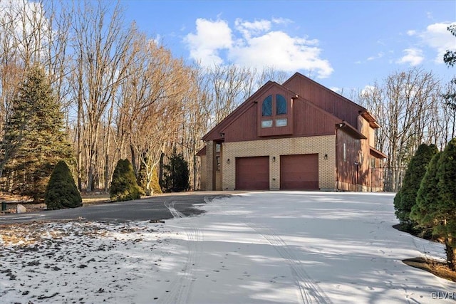 view of snow covered exterior featuring a garage