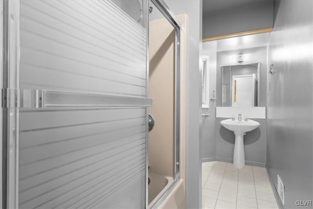 full bathroom featuring baseboards, bath / shower combo with glass door, and tile patterned floors