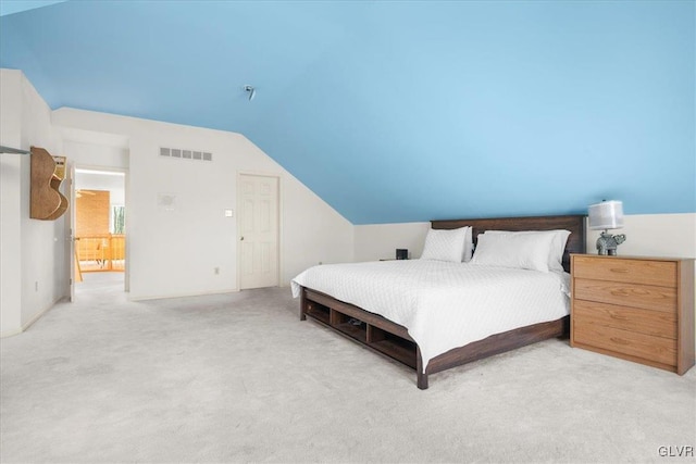 bedroom with light carpet, visible vents, and lofted ceiling