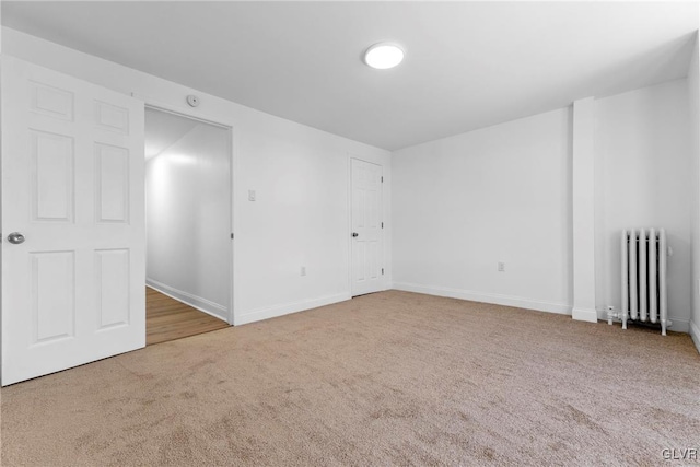 unfurnished room featuring radiator and carpet floors