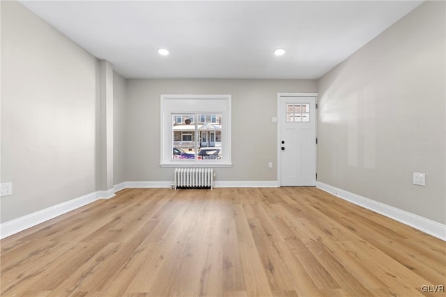 foyer with radiator and light hardwood / wood-style floors