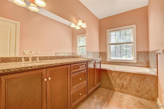 bathroom featuring vanity and a relaxing tiled tub