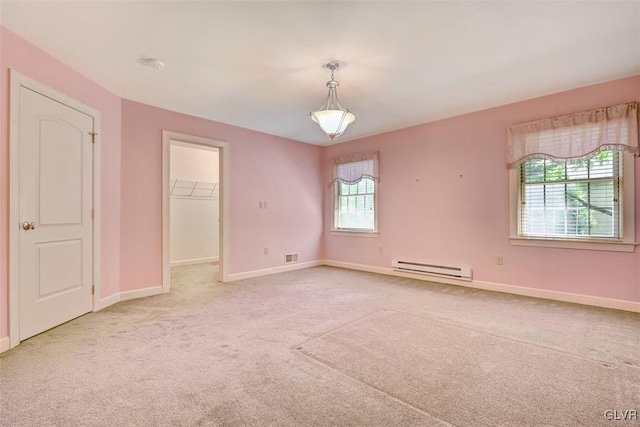 carpeted spare room with a wealth of natural light and a baseboard radiator