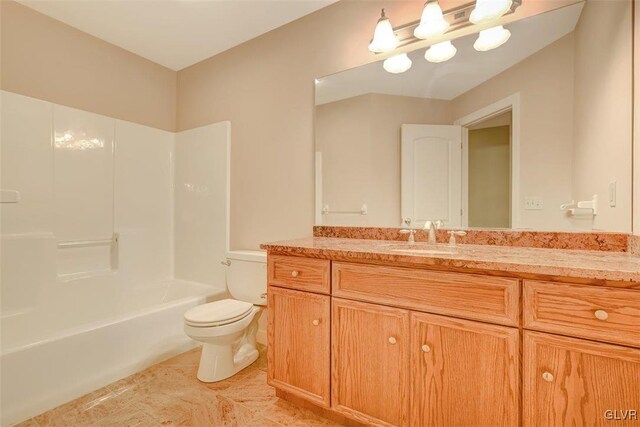 full bathroom with toilet, vanity, and washtub / shower combination