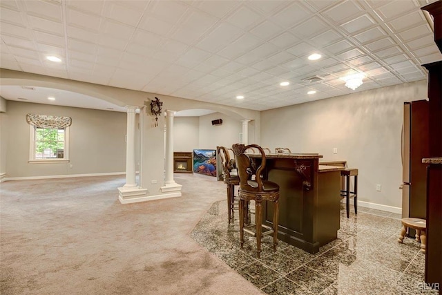 bar featuring decorative columns, carpet flooring, and stainless steel refrigerator