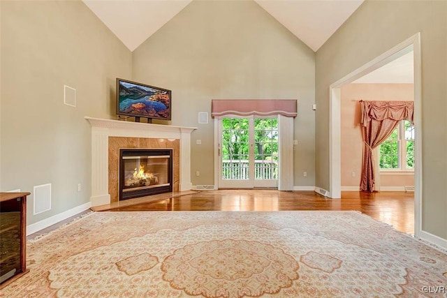 unfurnished living room featuring high vaulted ceiling, plenty of natural light, and a fireplace