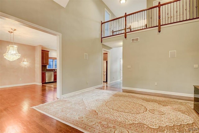 unfurnished living room featuring hardwood / wood-style flooring and a high ceiling