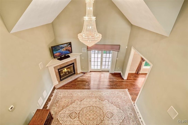 living room featuring wood-type flooring, a notable chandelier, and a premium fireplace