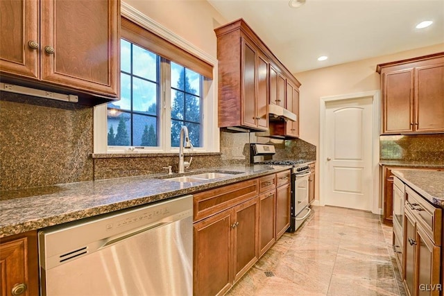 kitchen featuring decorative backsplash, sink, stainless steel appliances, and dark stone counters