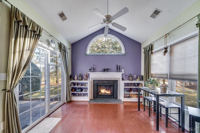 living room with ceiling fan, wood-type flooring, and lofted ceiling