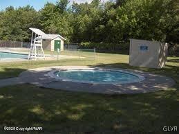 view of pool featuring a storage unit and a yard