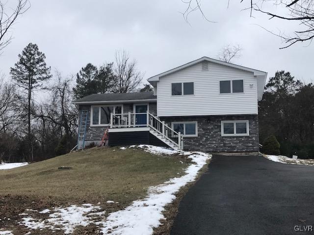 tri-level home with a porch and a yard