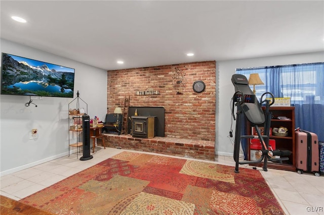 living area with light tile patterned floors, a wood stove, and recessed lighting