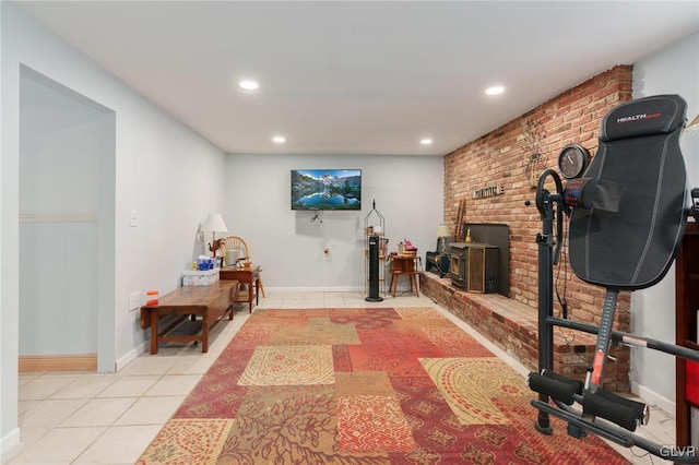 exercise room featuring recessed lighting, a wood stove, baseboards, and light tile patterned floors