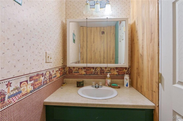 bathroom featuring wallpapered walls and vanity