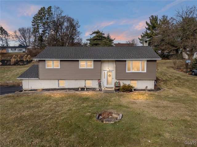 split foyer home featuring a yard