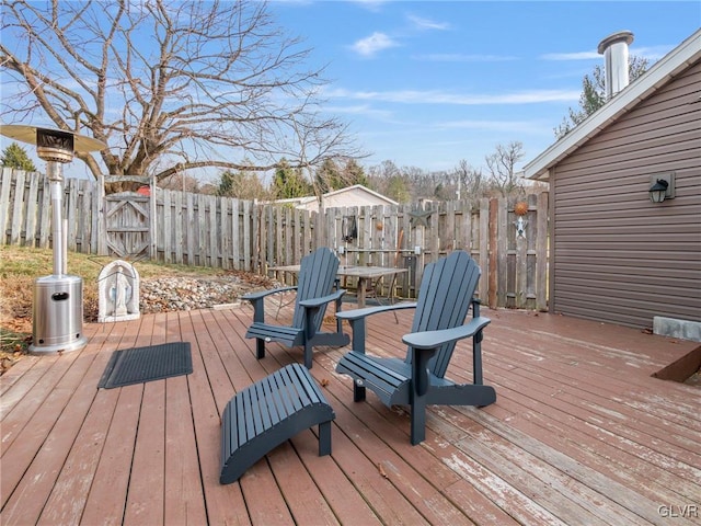 wooden deck with outdoor dining space, a gate, and fence