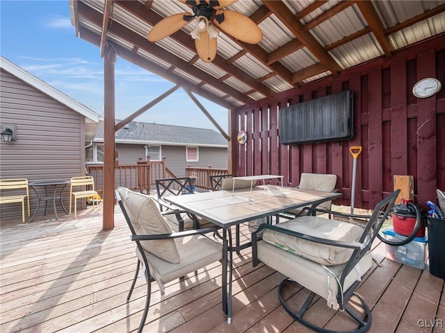 wooden deck featuring outdoor dining area and ceiling fan