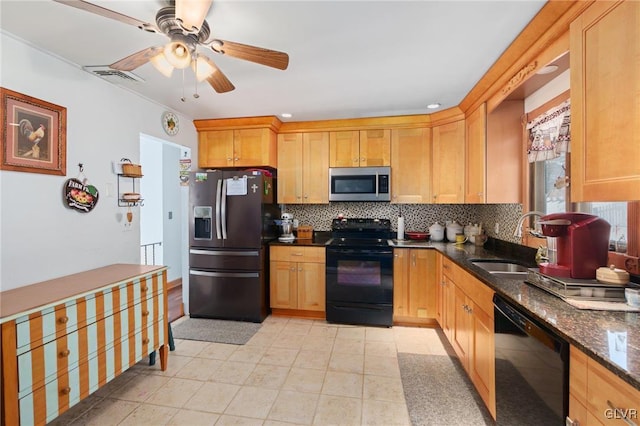 kitchen featuring black appliances, backsplash, dark stone countertops, and a sink