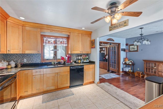 kitchen featuring dark countertops, a sink, backsplash, and black appliances