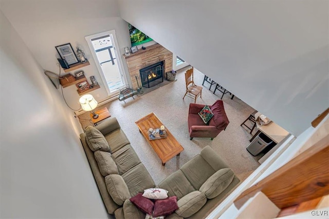 living room featuring vaulted ceiling and a stone fireplace