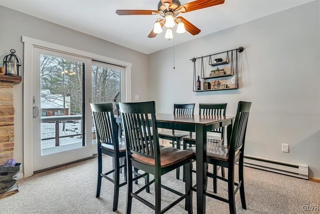 carpeted dining room with ceiling fan and a baseboard heating unit