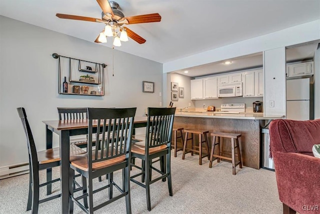 dining room with ceiling fan and light colored carpet