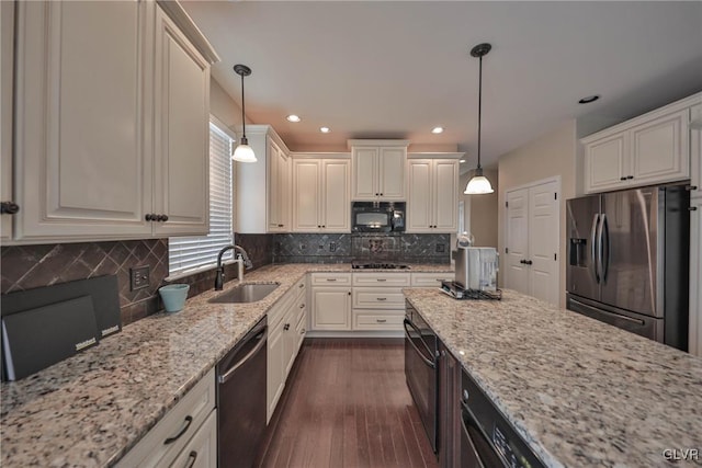 kitchen with black appliances, decorative light fixtures, light stone countertops, and sink