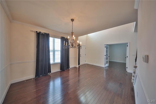 unfurnished dining area with an inviting chandelier, dark hardwood / wood-style flooring, and crown molding