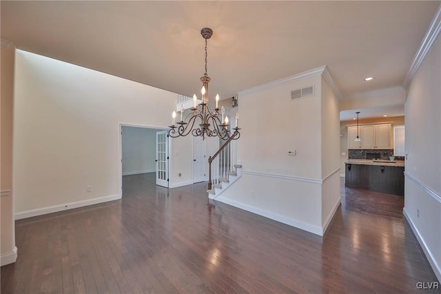 unfurnished dining area featuring a chandelier, crown molding, and dark wood-type flooring