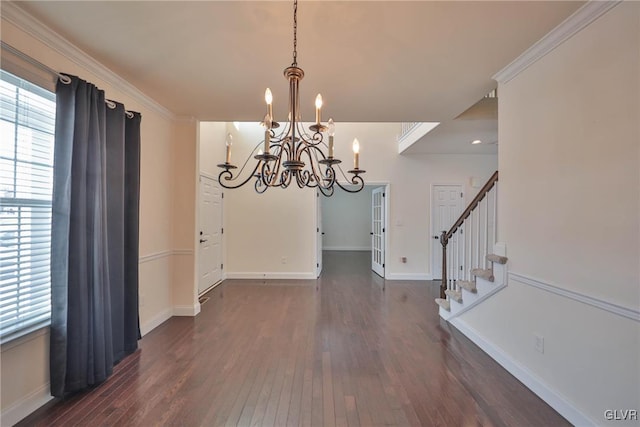 unfurnished dining area with dark wood-type flooring, a wealth of natural light, ornamental molding, and a notable chandelier