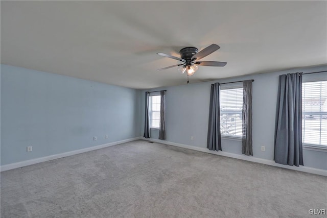 empty room featuring a healthy amount of sunlight, light colored carpet, and ceiling fan