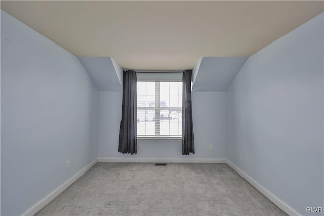 additional living space with vaulted ceiling and light colored carpet