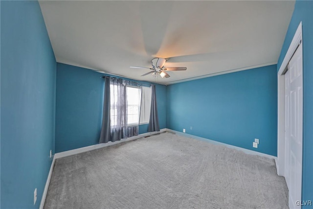 carpeted empty room featuring ceiling fan