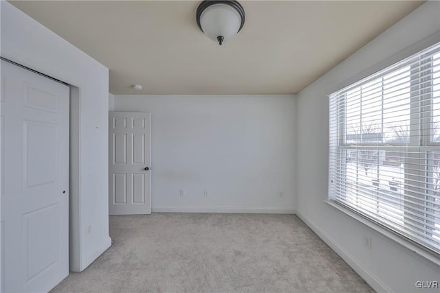 unfurnished bedroom featuring light colored carpet and a closet